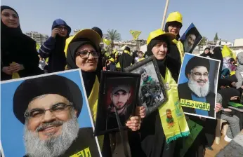  ?? AFP ?? Supporters hold portraits of Hezbollah leader Hassan Nasrallah at the rally in Nabatieh
