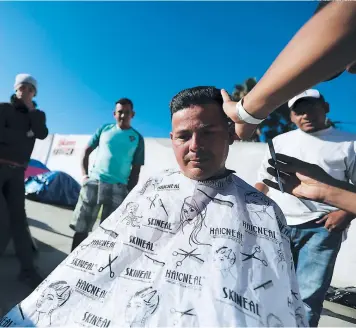  ?? FOTO: AGENCIA AP ?? El hondureño Daniel Villafranc­a corta el pelo en las calles de Tijuana para poder salir adelante.