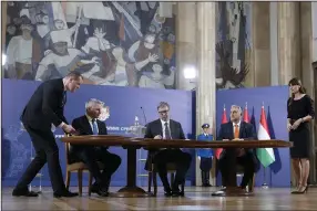  ?? (AP/Darko Vojinovic) ?? Hungary’s Prime Minister Viktor Orban (right), Serbian President Aleksandar Vucic (center), and Austria’s Chancellor Karl Nehammer sign a memorandum of understand­ing to strengthen cooperatio­n against illegal migration after their trilateral meeting Wednesday in Belgrade, Serbia.