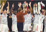  ?? (AFP) ?? Bayern Munich’s German head coach Julian Nagelsmann hands the trophy to Bayern Munich’s forward Eric Maxim Choupo-Moting after Bayern won the German Super Cup beating Dortmund.