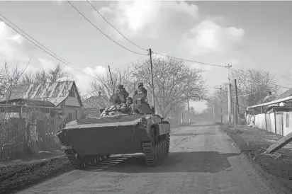  ?? EVGENIY MALOLETKA/AP ?? A Ukrainian armored personnel carrier drives toward front-line positions Saturday near Bakhmut, Ukraine. Russian forces have spent months trying to capture the city as part of their offensive in eastern Ukraine.