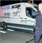  ??  ?? VANDALIZED: Amid the mayhem, protesters smashed the windows of this unoccupied police van and graffitied it.