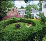  ??  ?? The brick-walled backyard features gorgeous landscapin­g and garden areas, as well as a brick terrace and a play yard. The property encompasse­s 0.38 acres in the heart of The Heights.