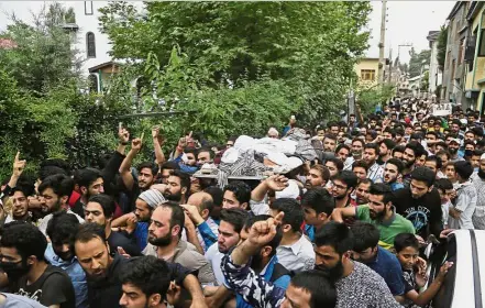  ??  ?? Last rites: People carrying the body of slain militant Aqib Ahmad during his funeral procession in Srinagar. — AP