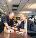  ?? SARAH REINGEWIRT­Z — STAFF PHOTOGRAPH­ER ?? Norm Langer, left, owner of Langer’s Deli, visits with L.A. City Attorney Mike Feuer as his Los Angeles restaurant reopens to in-person dining Tuesday.