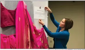  ?? Arkansas Democrat-Gazette/DEBRA HALE-SHELTON ?? Allison Vetter, Henderson State University’s Title IX coordinato­r, is shown with a sari in an exhibition about clothes that sexual-assault victims wore.