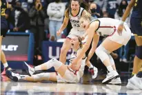  ?? JESSICA HILL/AP ?? Uconn’s Paige Bueckers, bottom left, reacts with teammates Caroline Ducharme, back, and Dorka Juhász in a Dec. 5, 2021, game against Notre Dame. All three dealt with injuries last season as the Huskies overcame adversity to reach the NCAA Tournament championsh­ip game.