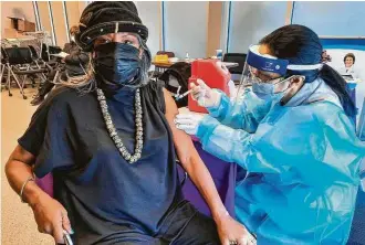  ?? Kenny Holston / New York Times ?? Adora Lee, 70, receives a vaccine in Washington in January. She and her mother obtained appointmen­ts after the city began giving priority to neighborho­ods hit hardest by the virus.