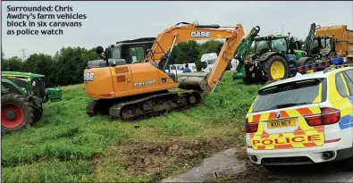  ??  ?? Surrounded: Chris Awdry’s farm vehicles block in six caravans as police watch