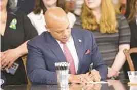  ?? BRIAN WITTE/AP ?? Gov. Wes Moore signs one of several gun-control measures during Tuesday’s bill-signing ceremony in Annapolis.