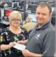 ?? DAVID JALA/CAPE BRETON POST ?? ServiCom call centre manager Todd Riley, right, shown with employee Susan Tucker and a long-awaited paycheque.
