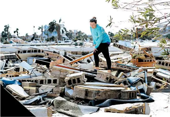  ?? GERALD HERBERT/AP ?? Mishelle McPherson looks for her friend Agnes Vicari in the rubble of her home in Mexico Beach last week. Vicari stayed in her home during the storm and has not been found.