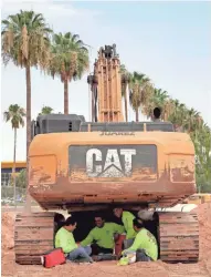  ?? ASSOCIATED PRESS ?? A crew from Juarez Constructi­on sits under an excavator to avoid the heat Tuesday in Tempe, Ariz.