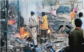  ?? FARAH ABDI WARSAMEH/AP ?? Somali soldiers inspect the wreckage after a truck bomb was detonated in Mogadishu on Saturday. At least 23 people were killed in the attack claimed by Islamic extremists.