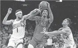  ?? JOE CAMPOREALE/USA TODAY SPORTS ?? Philadelph­ia 76ers guard Kelly Oubre Jr. (9) drives against Suns guard Devin Booker (1) and guard Grayson Allen during the second half on Wednesday at Footprint Center in Phoenix.