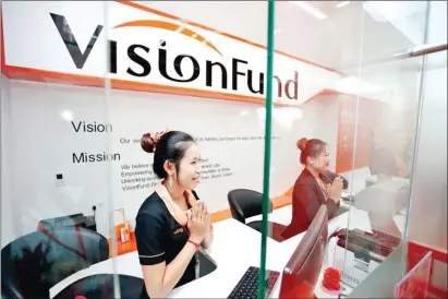  ?? HONG MENEA ?? Staff greet customers at a Vision Fund Microfinan­ce branch in Phnom Penh.