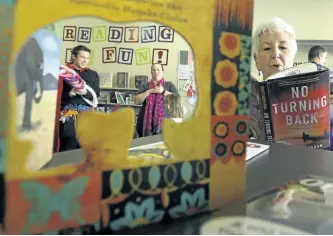  ?? CLIFFORD SKARSTEDT/EXAMINER ?? Wanda Pittman of Omemee District Lioness Club checks out a book on display as visitors celebrate the official opening of Kawartha Lakes Public Library Omemee Branch (relocated to 24 King St. East, the former Omemee Hardware Store location) on January 13.