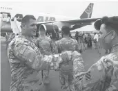  ?? STEPHEN B. MORTON/AP ?? Soldiers and command staffers bump fists at Hunter Army Airfield in Savannah, Georgia.