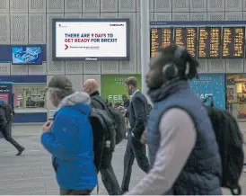  ?? /AFP ?? On track: Commuters pass an electronic billboard, operated by JCDecaux, featuring the UK government’s ‘Get ready for Brexit’ advertisin­g campaign, at London Bridge railway station.