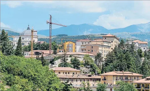  ?? STEFANO MONTESI - CORBIS / GETTY ?? Cicatrices. Las grúas de la reconstruc­ción forman parte del paisaje en el centro de L’Aquila. Abajo, el hemiciclo
del Consejo Regional