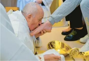  ?? VATICAN MEDIA ?? Holy Thursday ritual: Pope Francis kisses the foot of a female inmate during the foot-washing ceremony Thursday at the Rebibbia prison on the outskirts of Rome. The ritual, meant to emphasize service and humility, is a hallmark of Holy Week and recalls the foot-washing Jesus performed on his Twelve Apostles at the Last Supper.