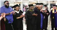  ?? (Pine Bluff Commercial/I.C. Murrell) ?? SEARK College officials including Barbara Dunn (second from left), executive director of institutio­nal advancemen­t and community relations; and Lozanne Calhoun (third from left), vice president for student affairs, congratula­te the graduates as they exit the arena.