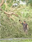  ?? JACK GRUBER, USA TODAY ?? Residents worked to clear trees and debris closing off neighborho­ods in Coral Gables, southwest of Miami.