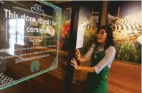  ?? ROSS D. FRANKLIN/ASSOCIATED PRESS ?? Belith Ariza, a barista trainer at Starbucks, opens the doors to the community meeting space Wednesday at a Starbucks Community Store in Phoenix. The Seattle-based company plans to open or remodel 85 stores by 2025 in rural and urban communitie­s across the U.S. That will bring to 100 the total number of community stores Starbucks has opened since it announced the program in 2015.