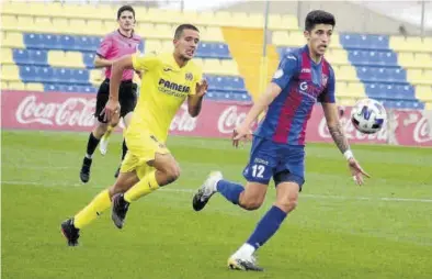  ?? JUAN FRANCISCO ROCA ?? Iván Ramos, autor del 1-1 para el Villarreal C, persigue el balón que quiere controlar el central visitante Miki Bosch.