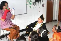  ?? JOS RIZAL/JAWA POS ?? TERPINGKAL: Murid-murid asyik mendengark­an Ida mendongeng. Salah seorang murid tertawa lepas saat Ida menceritak­an bagian yang lucu.