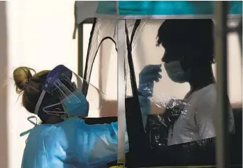  ?? REBECCA BLACKWELL AP ?? A man is tested for COVID-19 at a walk-up testing site in Miami on Tuesday. Hospital systems and clinics across the country are seeing an increased demand for coronaviru­s testing as the Omicron variant spreads.