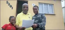  ??  ?? Anele Msomi (9) and Luyanda Msomi (13) from KwaNdengez­i celebrate with their grandfathe­r Mr TE Gumede who proudly holds the title deed to his own home. The home is now his asset to improve or even bequeath to heirs if hewishes.