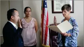  ?? Kevin Myrick / Standard Journal ?? Jose Iglesias is sworn in by Probate Judge Linda Smith while his wife Giovanna watches on Monday, Sept. 25.