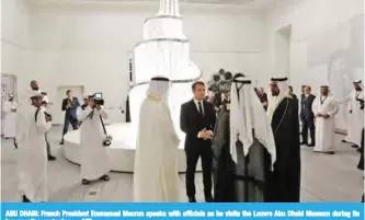  ?? — AFP ?? ABU DHABI: French President Emmanuel Macron speaks with officials as he visits the Louvre Abu Dhabi Museum during its inaugurati­on yesterday.