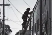  ??  ?? A firefighte­r climbs a ladder after the Oakland fire that may have killed dozens of people. Josh Edelson, AP