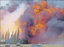  ?? THE TELEGRAM, FILE ?? A giant fireball is visible as a wildfire rips through the forest by Highway 63, 16 kilometres south of Fort McMurray, Alta. on Saturday, May 7. The wildfire has left economic scars as well as the destructio­n across the landscape.