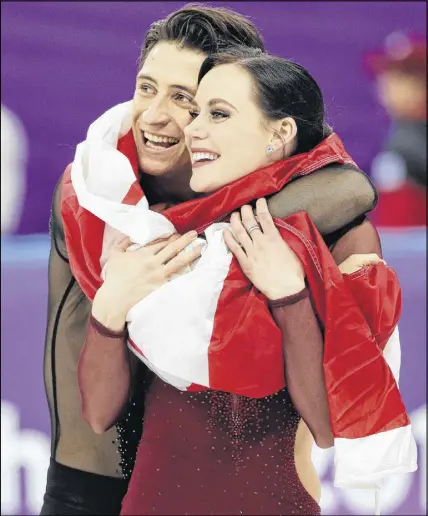  ?? AP PHOTO ?? Tessa Virtue and Scott Moir celebrate during the venue ceremony after winning the gold medal in the ice dance.