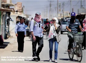  ??  ?? Liam in Za’atari refugee camp with Duha Jaafreh of World Vision