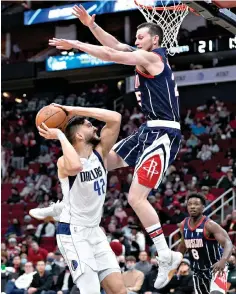  ?? AP Photo/Eric Christian Smith ?? ■ Dallas Mavericks forward Maxi Kleber (42) shoots as Houston Rockets guard Garrison Mathews defends Friday in Houston.