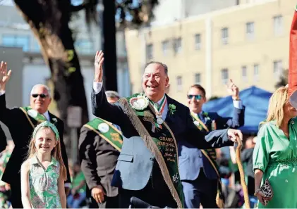  ?? PHOTOS BY RICHARD BURKHART/SAVANNAH MORNING NEWS ?? Parade Grand Marshal John Forbes encourages the crowd during the annual Savannah St. Patrick's Day Parade on Saturday.