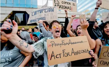  ??  ?? Activists demonstrat­e during a protest against Brazil’s President Jair Bolsonaro over the fires in the Amazon rainforest in front of Brazil’s Embassy in Santiago on Saturday. — AFP