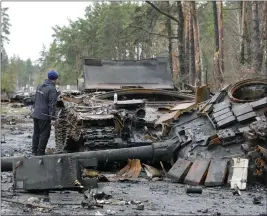  ?? EFREM LUKATSKY — THE ASSOCIATED PRESS ?? A local resident examines destroyed Russian tanks in the village of Dmytrivka close to Kyiv, Ukraine, on Saturday.