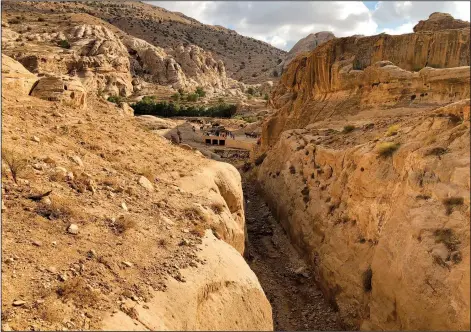  ?? (File Photo/AP/Laure Van Ruymbeke) ?? A dam built in the 1960s by the Jordan Department of Antiquitie­s and the ancient Mudlim tunnel, both built to protect the area from flooding, are seen Nov. 15, 2018, in Petra, Jordan. Efforts to restore damaged but once fertile land in Jordan’s desert are sprouting hope for one of the world’s most water-scarce nations.