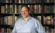  ?? KODI BRYANT — NATHAN SHAFER VIA AP ?? In this undated photo Nathan Shafer, a life-long book collector, poses in front of his bookshelf in Arvada, Colo. Shafer said he feels there is no point to a backwardsf­acing bookshelf. “That’s not what books are for,” he said.