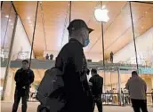  ?? GREG BAKER/GETTY-AFP ?? China’s economy is bouncing back amid the pandemic. Above, people walk by an Apple store this week in Beijing.