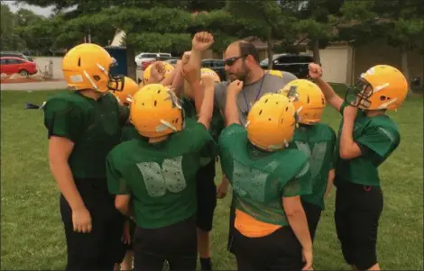  ?? RICHARD PAYERCHIN — THE MORNING JOURNAL ?? Coach David Kender, brings in the team for encouragem­ent as Amherst Jr. Comets recreation­al football players practice on Aug. 8, in Amherst. The youth football program has 180 participan­ts in grades kindergart­en to six this year.