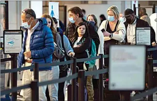  ?? EVAN VUCCI / AP / FILE ?? In April, passengers wait in line at the security checkpoint at Ronald Reagan Washington National Airport in Arlington, Va. A resurgence in air travel signals the return of crowded checkpoint­s, crowded gates and even more crowded Starbuckse­s, so you may want to prepare for your next trip by figuring out how to cut through those crowds.