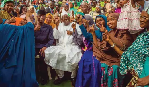  ??  ?? Vice-President Yemi Osinbajo and Abdullahi Ganduje, Governor Kano State surrounded by appreciati­ve beneficiar­ies of FG’s interest-free loans dubbed GEEP-MarketMoni at an interactiv­e session with the Vice President in Kano.