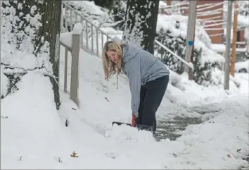  ?? Pittsburgh Post-Gazette ?? Dawn Penrod shovels snow on the sidewalk Thursday in front of her Forest Hills home.