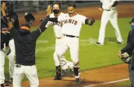  ?? Santiago Mejia / The Chronicle ?? Donovan Solano and his Giants teammates are exuberant after his tworun homer in the 11th inning.